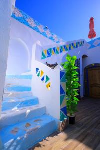 a staircase in a house with blue ceilings and a plant at Nubian Popeye - Roof top - Nile View in Aswan