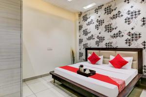 a bedroom with a large bed with red pillows at Super OYO Flagship Hotel Sky Land in Ludhiana