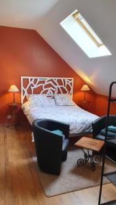 a bedroom with a bed and two chairs and a skylight at La Ferme de Couffy in Couffy +39 photos