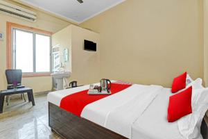 a bedroom with a large bed with red pillows at Flagship Pratap Guest House in Sultānpur