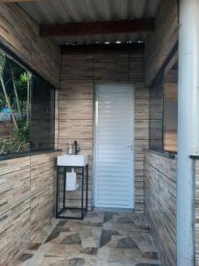 a bathroom with a sink and a white door at Chacara in Atibaia