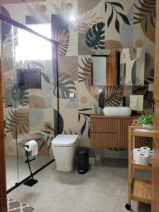 a bathroom with a toilet and a glass shower at Chacara in Atibaia