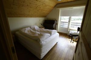 een kleine slaapkamer met een bed en een raam bij Artun Guesthouse in Artun