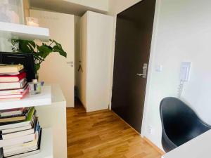 a room with a black door and a chair and books at Studio apartment 10mins from Oslo Cent. station. in Oslo