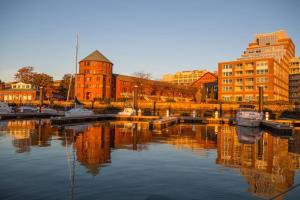una città con edifici e barche in acqua di Sea Pearl Boston Yacht a Boston