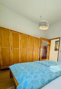 a bedroom with wooden cabinets and a blue bed at Attraktive Wohnung im grünen Hinterhof in Schwerin