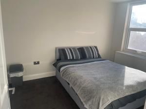 um quarto com uma cama num quarto com uma janela em Double Bedroom em Londres