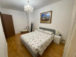 1 dormitorio con cama y lámpara de araña en Villa Gurrieri, en Roma