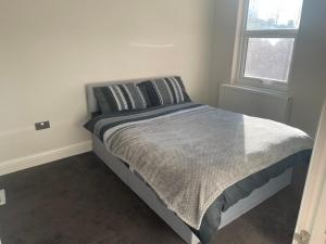 uma cama num quarto branco com uma janela em Double Bedroom em Londres