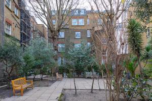 a park with a bench in front of a building at Luxurious Apartment in Kensington in London