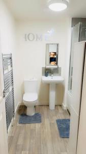 a bathroom with a toilet and a sink at Mo Apartment in Accrington