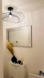 a mirror on a wall above a refrigerator with a fan at Mo Apartment in Accrington