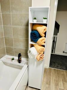 een witte kast in een badkamer met handdoeken bij Mo Apartment in Accrington