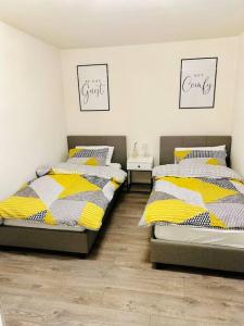 two twin beds in a bedroom with two tables at Mo Apartment in Accrington