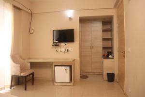 a room with a desk and a tv on the wall at Padmanabha Apartments in Vrindāvan