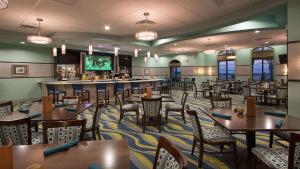 uma sala de jantar com mesas e cadeiras e um bar em 817JE CHAMPIONS GATE,CONDO + GAME ROOM em Kissimmee