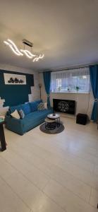 a living room with a blue couch and a table at Quiet Basement Apartment in Poznań