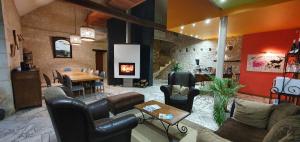 a living room with leather furniture and a fireplace at La Ferme de Couffy in Couffy