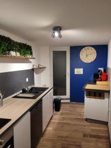 a kitchen with a counter and a clock on the wall at Effet Mer, 4 etoiles, gîte de 80m2 in Dorlisheim