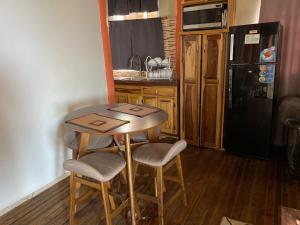 a small kitchen with a wooden table and chairs at Elite's Ocean View in Montego Bay