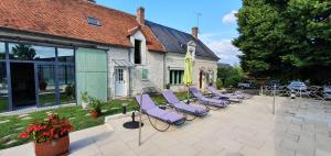 a row of purple chairs sitting in front of a building at La Ferme de Couffy in Couffy