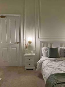 a bedroom with a bed and a nightstand next to a door at Victorian Stay in Ocean village in Southampton