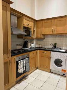 een keuken met een wasmachine en een vaatwasser bij Victorian Stay in Ocean village in Southampton