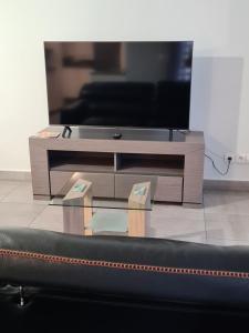 TV sentada sobre una mesa de centro en Appartement de standing au centre de Chassieu en Chassieu