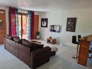 un soggiorno con un divano e un tavolo di Le chal'heureux a Chirongui