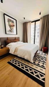 um quarto com uma cama e uma grande janela em Newton’s Place - Luxury styled 2 BD Apartment em Midrand