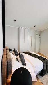 um quarto com uma cama grande e paredes brancas em Newton’s Place - Luxury styled 2 BD Apartment em Midrand