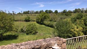 a view of a field with a stone wall and trees at Papillons B&B - beauty, comfort and peace 25 mins from Puy du Fou in Montournais