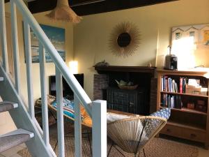 a living room with a staircase and a book shelf at Papillons B&B - beauty, comfort and peace 25 mins from Puy du Fou in Montournais
