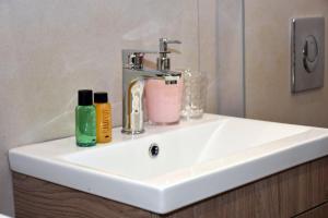 a bathroom sink with two soap bottles on it at Olgas cozy home in Chania Town