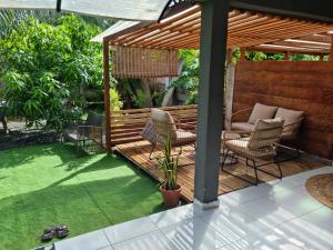 pergolato in legno con sedie e tavolo di Le chal'heureux a Chirongui