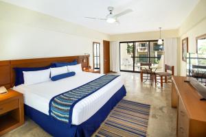 - une chambre d'hôtel avec un lit et un bureau dans l'établissement Plaza Pelicanos Grand Beach Resort All Inclusive, à Puerto Vallarta