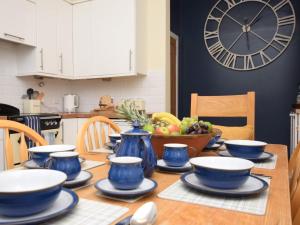 una mesa de comedor con platos azules y un reloj en la pared en 3 Bed in Cove 73939, en Cove