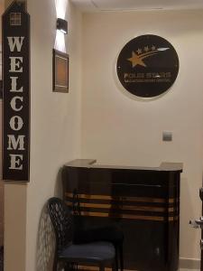 a table with a chair and a sign on a wall at Four Stars Hostel in Dubai