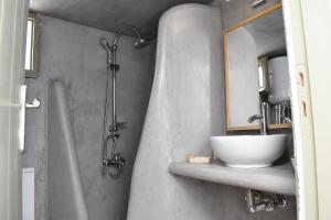 ein Badezimmer mit einem Waschbecken, einem Spiegel und einer Badewanne in der Unterkunft Chora Cozy Studios in Kythnos