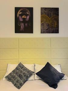 - un lit avec 2 photos sur le mur et 2 oreillers dans l'établissement La Cornice Apartment, à Rome