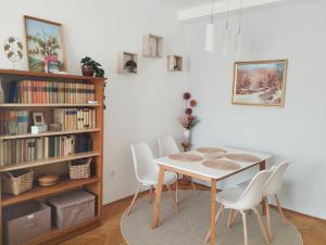a dining room with a table and white chairs at Greenview Apartment in Budapest