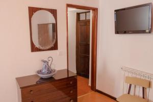 um quarto com um espelho e um vaso numa cómoda em Casa Do Peirão 