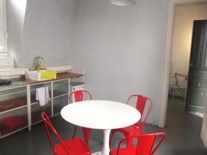 a white table and red chairs in a kitchen at Casa San Telmo 3081 in Buenos Aires