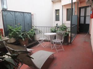 a patio with chairs and a table and some plants at Casa San Telmo 3081 in Buenos Aires
