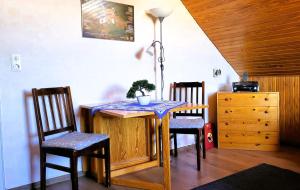 einen Esstisch mit 2 Stühlen und einer Lampe in der Unterkunft Harz de luchs in Bad Harzburg