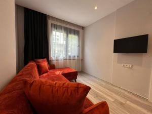 Il comprend un salon doté d'un canapé et d'une télévision à écran plat. dans l'établissement Lara's Suite Antalya 10, à Antalya
