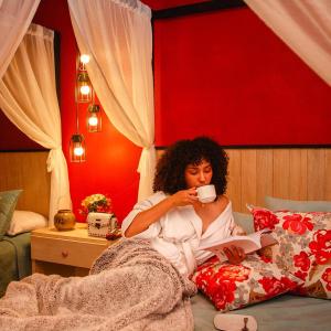 Eine Frau im Bett mit einer Tasse Kaffee in der Unterkunft Corregidora 12 in San Cristóbal de las Casas