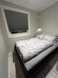 a large bed in a room with a window at Leilighet med strandbeliggenhet in Ramberg