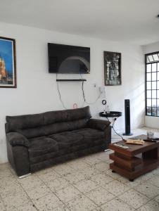 sala de estar con sofá de cuero marrón y mesa en Casa, en San Miguel de Allende
