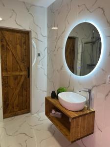een badkamer met een wastafel en een grote spiegel bij Hellene Snow Starý Smokovec in Stary Smokovec